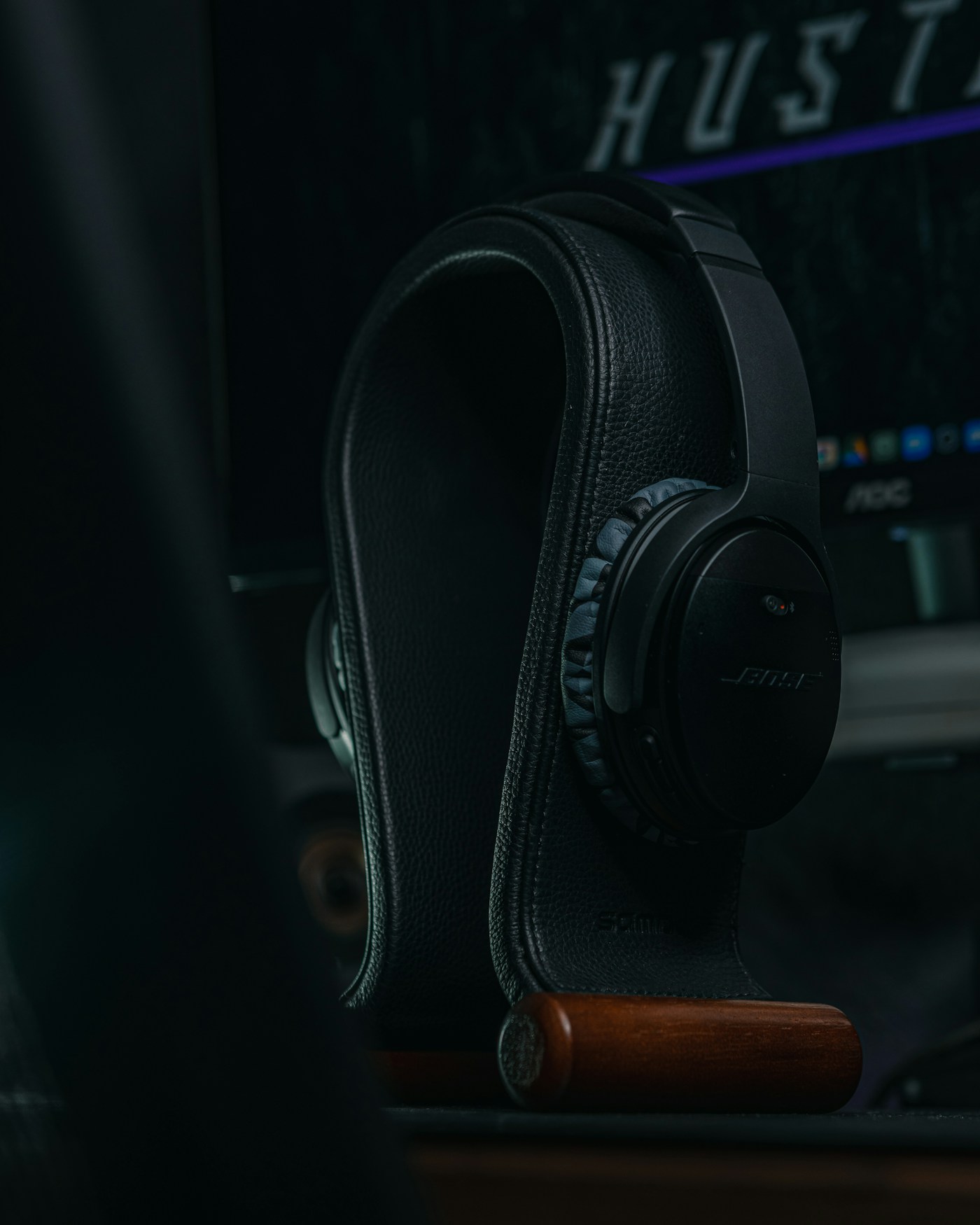 Close-up of studio headphones on a stand in a dark room, warm backdrop
